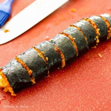 Lightly brush sesame oil over each kimbap roll and onto a sharp knife. Firmly slice each roll into ¾-inch wide pieces. Rinse the knife with warm water to between slicing each roll to ensure a clean cut.
