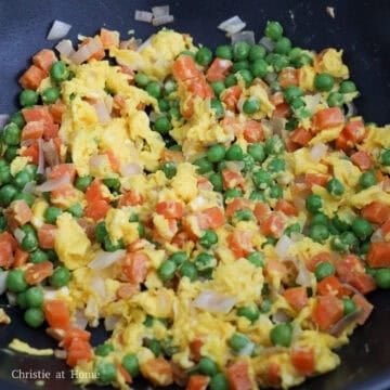 Add remaining oil into empty space of the pan. Add in beaten eggs and let them sit for 20 seconds before scrambling and breaking into bite-sized pieces. Then toss everything together.