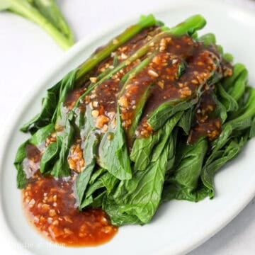 Pour the garlic sauce over the greens. Serve and mix the greens with the sauce to enjoy!