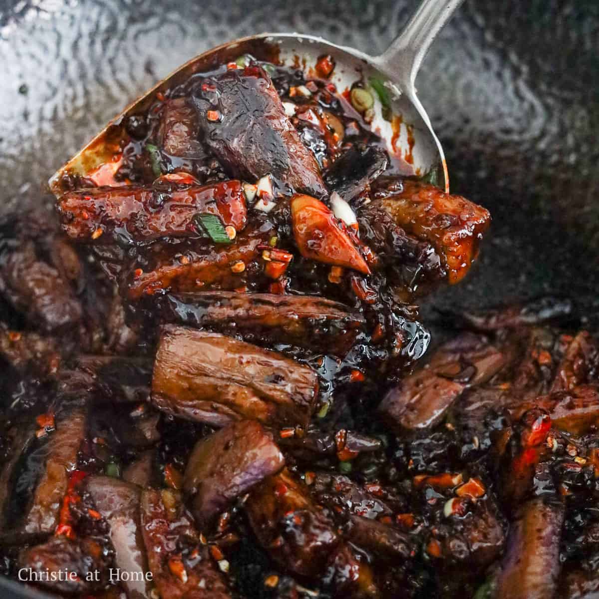 Eggplant tossed in a glossy sauce in the pan until evenly coated and ready to serve.