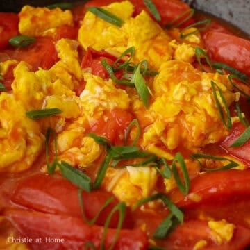 Add the cooked eggs and gently fold them into the sauce and tomatoes. Remove the pan from the heat source. Garnish with the remaining green onions.  If needed, season with more salt to taste. Serve and enjoy with steamed rice or noodles!