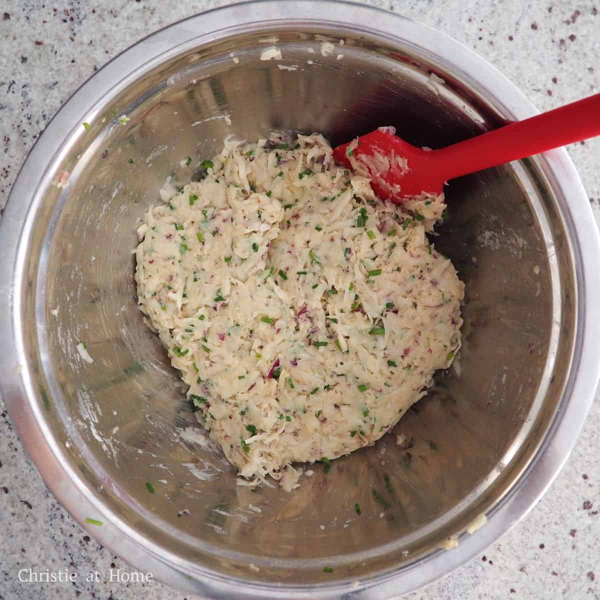 In a large mixing bowl, add in the shredded potatoes, onions, chopped chives, eggs, all-purpose flour, salt, and black pepper. Mix until well combined.