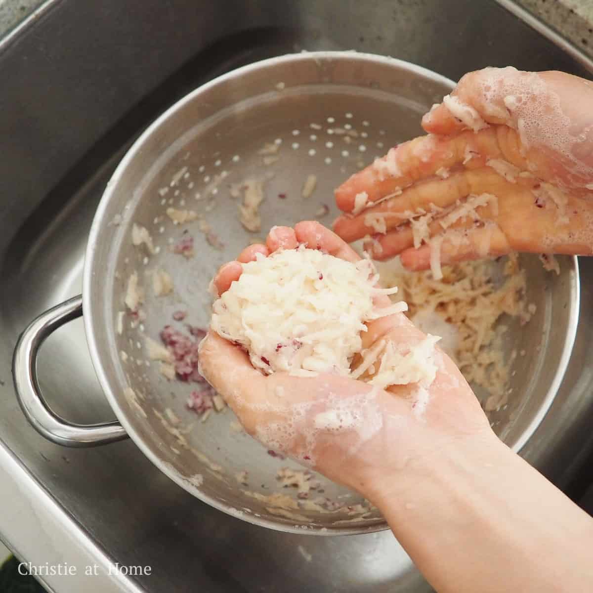 Transfer the shredded potatoes and onions into a large clean tea towel or cheese cloth and tightly twist the cloth to wring out as much liquids in the potatoes and onions as possible. Alternatively, you can also use clean hands to squeeze out as much liquid over a colander.