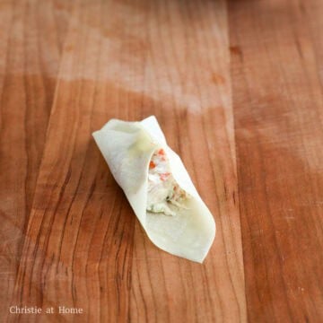 Pinch the two opposite corners of the wrapper together.