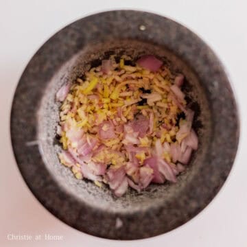 Into a mortar and pestle, food processor or blender, add prepared shallots, white parts of the lemongrass, garlic, ginger and salt. Then pulverize with a pounding motion until the aromatics become a thick paste or blend on high speed until you have a grounded paste. Add the paste to the bowl of chicken wings.