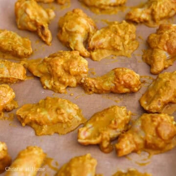 Line a large baking sheet with parchment paper. Give the wings another mix in the coating. Then place coated wings onto the baking sheet in a single layer, giving each wing enough room.
