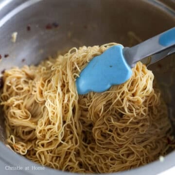 Transfer the hot noodles to a large mixing bowl and mix in the noodle sauce.