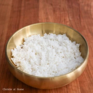 Place hot cooked rice in a large serving bowl and cover to keep warm. Set aside.