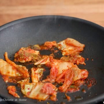 In the same pan on low-medium heat, add remaining vegetable oil. Sauté chopped kimchi for 30-45 seconds until warm and transfer over the cooked eggs.