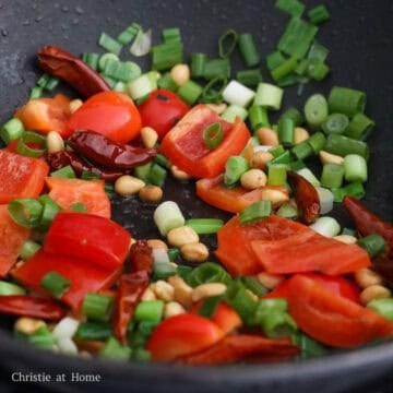 Stir-fry the dried red chilis, green onions, and peanuts for 15 seconds. Add the red bell peppers and stir-fry for another 30 seconds.