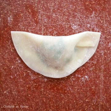 Fold the wonton wrapper over the filling into a semi-circle or triangle shape and pinch and seal the edges tightly.