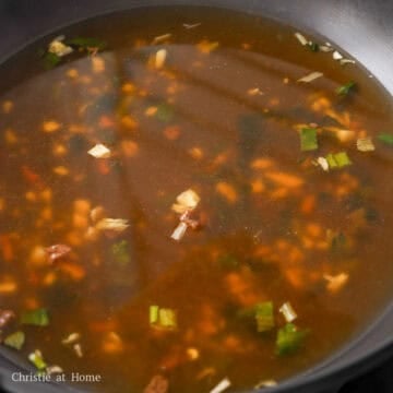 In a large shallow pan, add cold water, instant ramen soup seasoning, instant dried vegetable flakes if available, and garlic. Bring to a rolling simmer over low-medium heat. Do not turn heat past this or it’ll evaporate the water quickly.