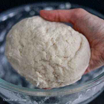 In a separate large mixing bowl, whisk flour and salt together. Make a well in the center of the flour mixture and then pour hot boiling water into it. Then whisk together until it forms a clumpy ball. If the dough is too sticky to work with, sprinkle a few more tablespoons of flour over top and knead it into a evenly shaped ball until it's no longer sticky. There's no need to proof the dough.