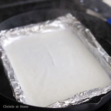 Mix the batter again and then pour ½ cup or 250 ml into the tray, aiming for the middle, to create a thin rice noodle sheet.