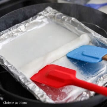 Next turn off the heat completely and remove the lid. Use two spatulas or a dough cutter to lift the edge of the rice noodle sheet and roll it away from you. The roll should be 1 inch thick.