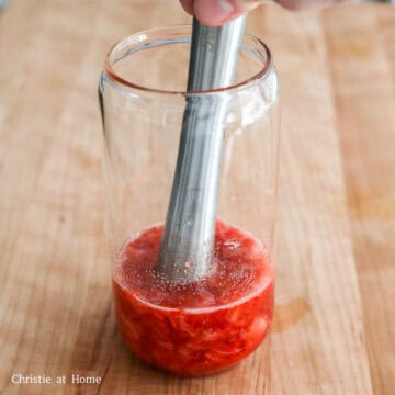 In a tall glass, add chopped strawberries and white granulated sugar and crush them with a muddler until they’re puréed. If you don't have a muddler, blend the strawberries and sugar in a blender or food processor or finely chop the berries with a knife and transfer to the drinking glass.