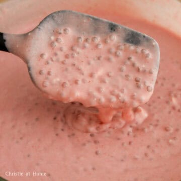 Strawberry puree being poured into the tapioca and coconut milk mixture and stirred until fully combined.