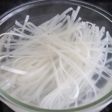 Soak rice noodles in very hot boiling water until limp but firm (about 2-4 minutes) or in warm water for 15 minutes if you have time. Strain immediately. Set aside.