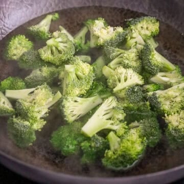 Fill a large pan halfway with water and bring to boil. Once it boils, add broccoli and blanch for 1-2 minutes or until vibrant green. Strain broccoli and pour out water. Dry the pan.