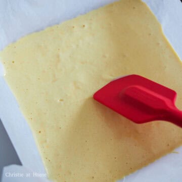 Pour the cake batter into the lined baking pan. Tap the pan on a flat surface to release any bubbles and smooth out the top with a spatula.