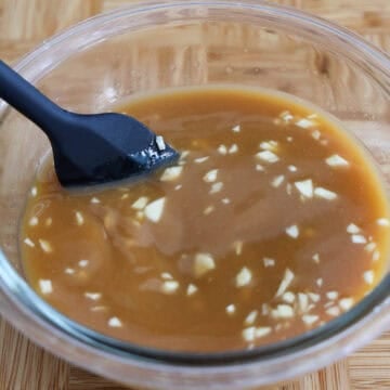 Small bowl with mixed orange sauce ingredients stirred together until smooth and well combined.