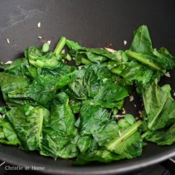 Add 1 teaspoon / 5 ml vegetable oil into the pan. Then add minced garlic and chopped Chinese broccoli. Cook for 30-60 seconds or until leaves have softened. Push everything to the side of the pan.