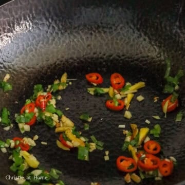 Reserve 2 teaspoon of the oil in the pan and discard the rest. Reduce to low heat, sauté ginger, garlic, red chili, green onion, and sugar for 30 seconds.