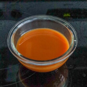 Sauce ingredients being mixed in a small bowl until the sugar is fully dissolved.