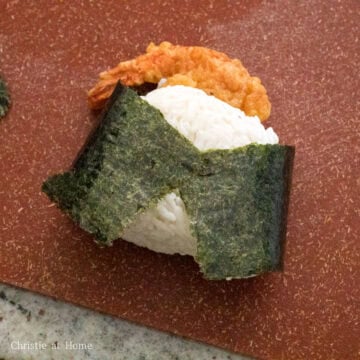 Remove the rice ball from the plastic wrap and wrap it with a strip of nori around the rice part. Repeat this until you have 7 more rice balls. Enjoy!