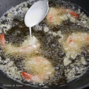 In a large heavy bottomed pan, heat vegetable oil on medium high heat until you reach 350 degrees F with a digital instant read cooking thermometer or insert a wooden utensil and look for rapid bubbles. Fry battered shrimp in small batches, about 3-4 pieces per batch. Drizzle 2 teaspoon of excess batter on top of each piece of shrimp, flip it over and let this fry for 1 minute or until crispy. Then drizzle another 2 teaspoon of batter, flip over and fry for another 1 minute or until it's crispy.