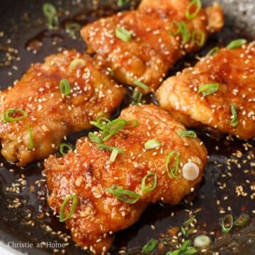 Add the chicken skin-side down into the sauce. Then quickly flip it over to coat the other side. Remove off heat. Garnish with sesame seeds and green onions. Serve as whole pieces or let it rest for 5 minutes and slice thighs into strips. Enjoy!