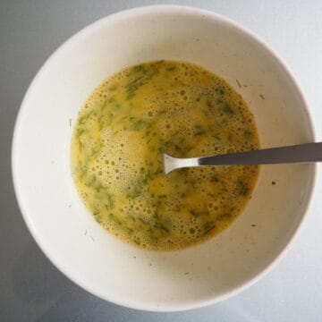 In a large bowl, crack your eggs. Add your finely chopped fresh dill along with 1 teaspoon of melted butter. Whisk eggs until well combined.