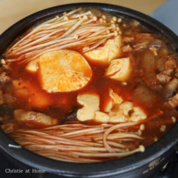 Add in enoki mushrooms in two bunches beside the tofu. Let this simmer for 1 minute.Â