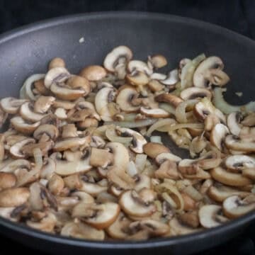 Toss in sliced mushrooms. Then add ¼ cup water. Cook until mushrooms have softened, about 5 minutes, and most of the liquids in the pan have evaporated.