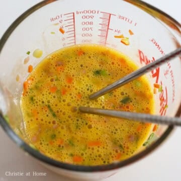 In a large bowl or measuring cup with a lip, whisk eggs and mix in ham, carrots, green onions, sesame oil and salt