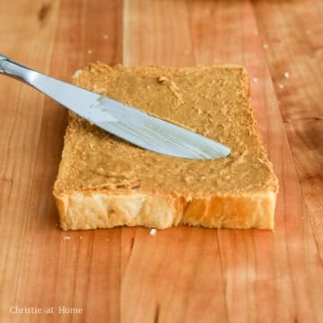 Evenly spread peanut butter on two slices of bread leaving the third plain.