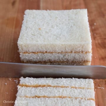 Slice off the crusts of each sandwich.