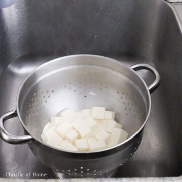 Gently strain tofu into a colander. Do not rinse off with cold water.