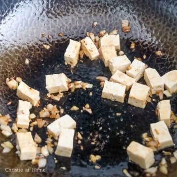 If needed, add another 1 tablespoon of oil. Fry shallots and garlic for 10 seconds. Add firm tofu and gently toss for 20-30 seconds.