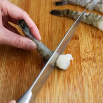 To straighten the shrimp: Turn the shrimp over its back side and make small slits where the feet used to be with a knife and snap the shrimp until you feel a break. The more slits the flatter the shrimp will be.
