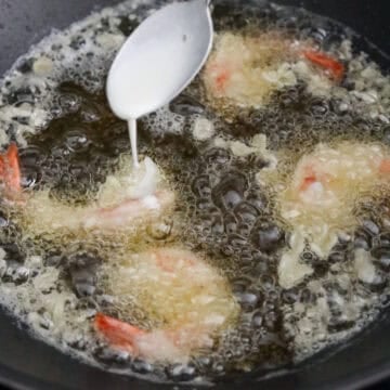 Drizzle 2 teaspoon of excess batter on top of each piece of shrimp, flip it over and let this fry for 1 minute or until crispy. Then drizzle another 2 teaspoon of batter, flip over and fry for another 1 minute or until it's crispy.