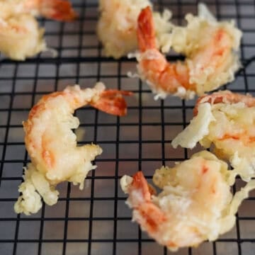Remove fried shrimp with tongs or a slotted spoon and transfer to a wire rack or paper towel baking sheet to allow excess oil to drip off. Repeat for the remaining shrimp.