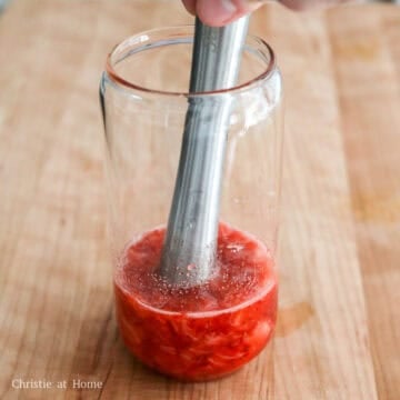 Add the strawberries and sugar to a tall 16-oz drinking glass. Using a muddler, crush the strawberries until they release their juices and form a purée.
