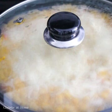 Corn cheese topped with mozzarella, covered in a pan while the cheese melts.