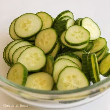 Slice the ends of the cucumber and thinly slice into ¼-inch thick pieces. Transfer sliced cucumbers into a large bowl.