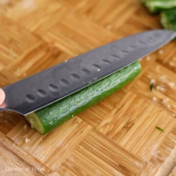 Remove the ends of the cucumbers and smash them with the side of your knife a few times until broken down.