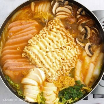 Place instant ramen noodles on top of the stew with a slice of cheese on the noodles. Boil ramen for 2 minutes or until Al Dente texture. Depending on the size of your pan, you may need to boil the ramen cakes one at a time and remove cooked noodles from the broth so they don't get soggy. Enjoy the hot stew with steamed rice!