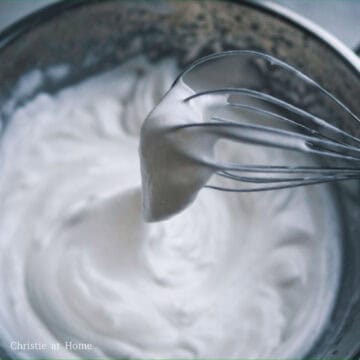 In another large mixing bowl, add egg whites and white vinegar. With a hand mixer, whisk at a medium speed and then increase to high speed while gradually adding white granulated sugar in three portions. Beat egg whites just until you reach stiff peaks. Do not over beat or it can cause deflated pancakes. To check if egg whites are stiff enough, dip whisk into the meringue and lift it out of the bowl. If meringue does not drip, it is stiff enough.