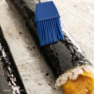 Brush sesame oil onto the gim of the kimbap and onto the blade of a sharp knife.