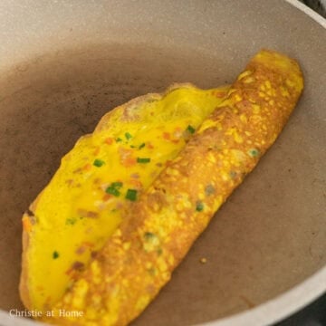 Pan fry until the omelette is mostly cooked and the edges lift away from the pan. Gradually roll it 75% of the way and gently flatten the egg roll with two spatulas so the layers can stick together.